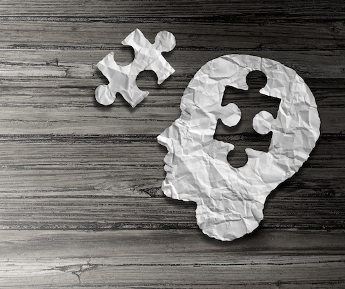 artistic rendering: paper cutout of a head with a puzzle piece taken out